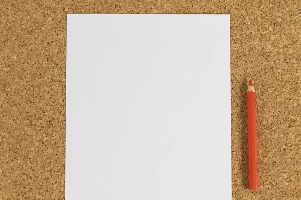 Black white paper with red pencil on cork background