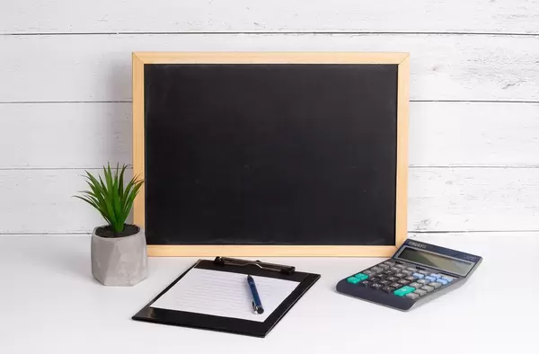 Blackboard with calculator and notepad