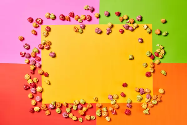 Blank yellow paper with popcorns on colorful background