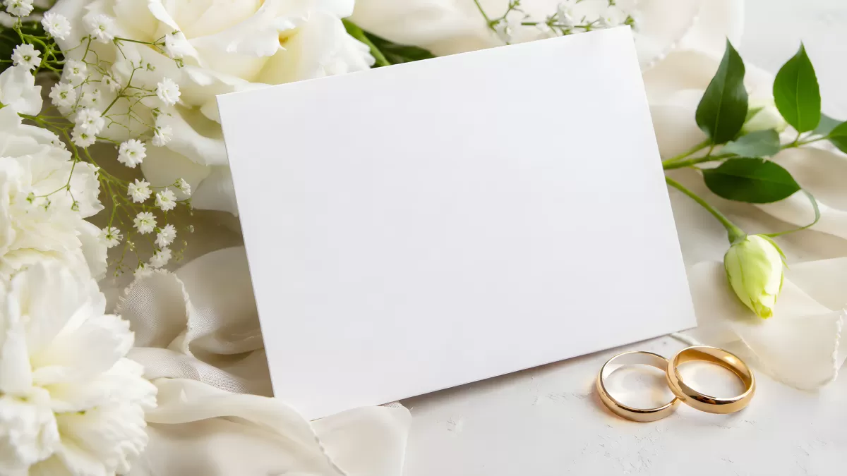 Blanke Hochzeitskarte mit Eheringen und weißen Rosen