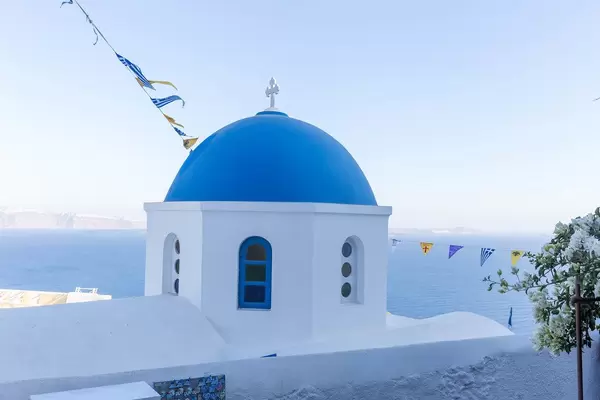 Blau und weiß auf der Insel Santorini: Kirche mit blauer Kuppel, Meer und Himmel