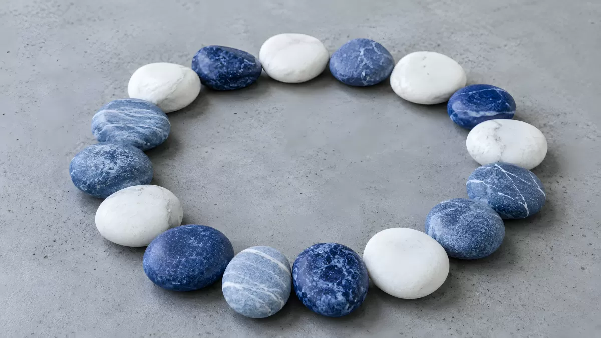 Blau-weiße Steine in einem Kreis auf grauem Untergrund