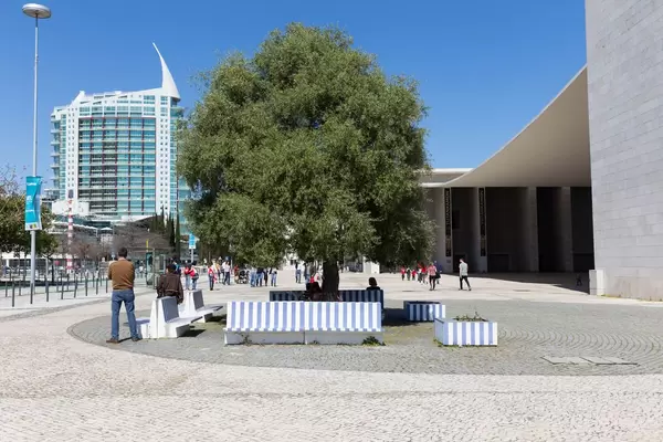 Blau-weiße Sitzbänke mit dem Gebäude Torre São Gabriel im Hintergrund - Lissabon, Portugal