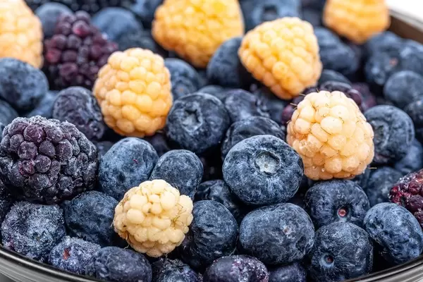 Blaubeeren, gelbe Himbeeren und Maulbeeren in einer Schüssel Nahaufnahme