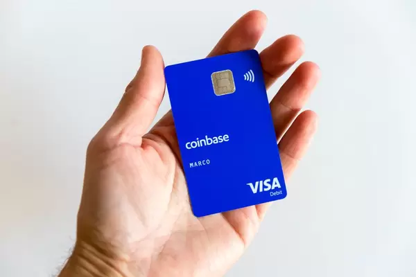 Blaue Coinbase-Karte mit Visa Debit Logo, mit Kryptowährungen wie mit Geld zahlen