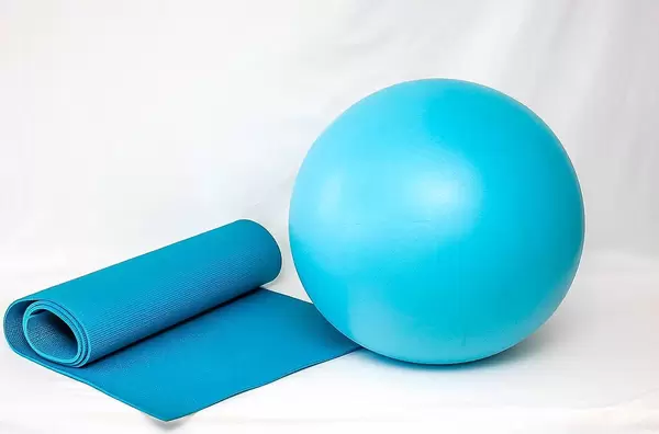 Blaue Fitnessmatte zum Meditieren und Gymnastikball