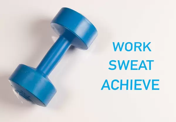 Blaue Sport-Hantel vor weißem Hintergrund mit dem Text "Work Sweat Achieve" (Arbeite, Schwitze, Erreiche)