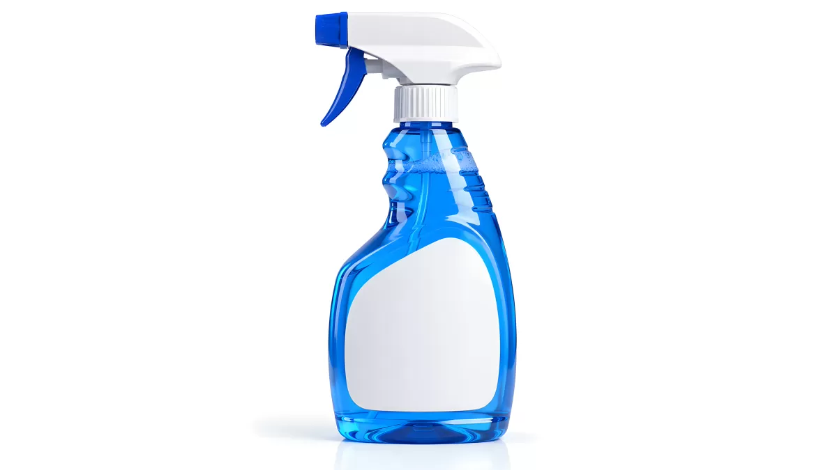 Blaue Sprühflasche mit weißem Etikett auf hellem Hintergrund