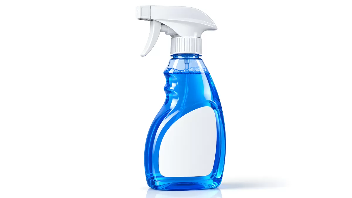 Blaue Sprühflasche mit weißem Etikett vor weißem Hintergrund