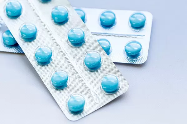Blaue runde Tabletten in Packungen