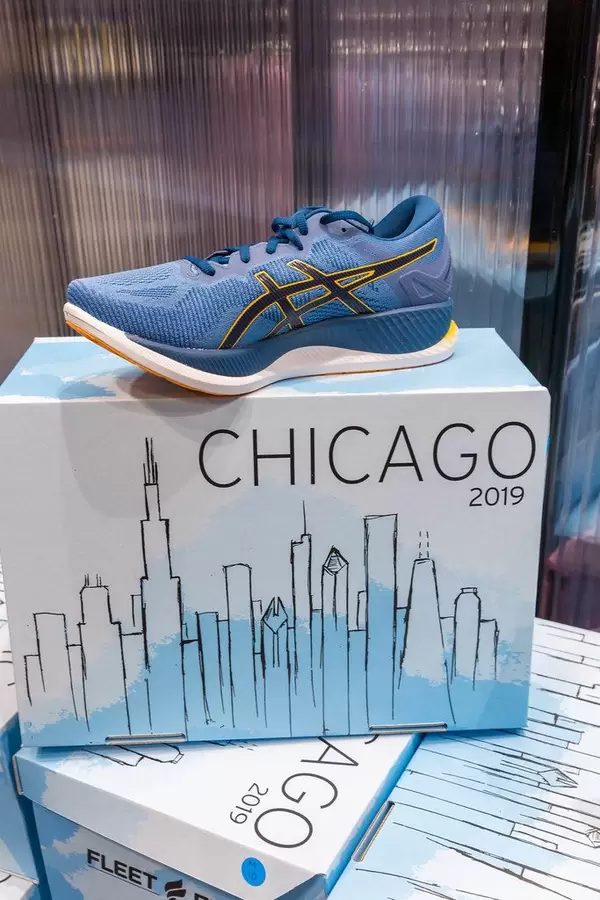Blauer GlideRide Sportschuh von asics auf dem Schuhkarton im Chicago-Marathon 2019 Design