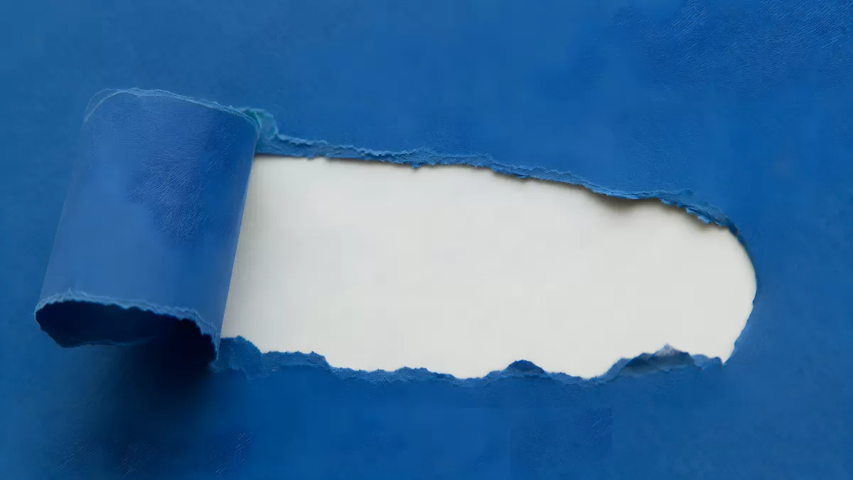 Blaues Papier wird aufgerissen und gibt weiße Fläche frei