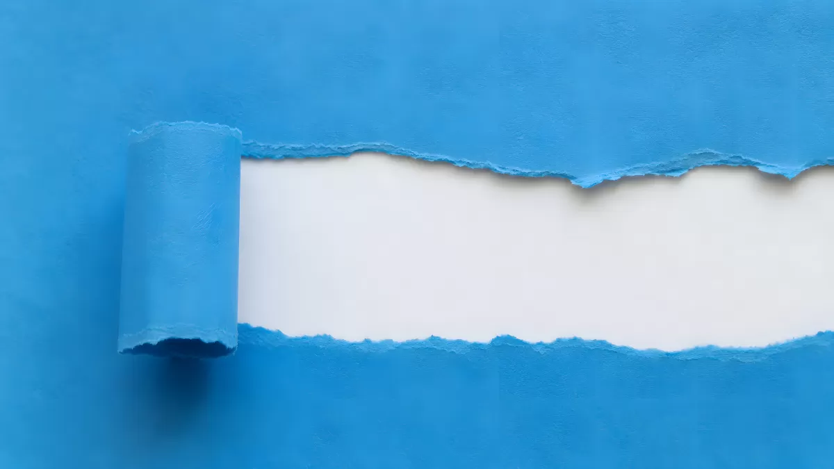 Blaues Papier wird aufgerollt und enthüllt weißen Hintergrund