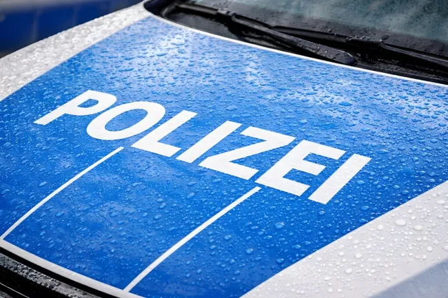 Blaues Polizeiauto bei Regen - Nahaufnahme der Motorhaube