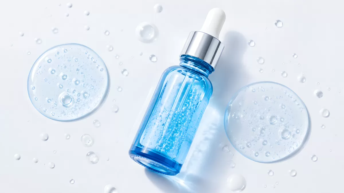 Blaues Serum-Fläschchen mit Pipette auf weißem Untergrund