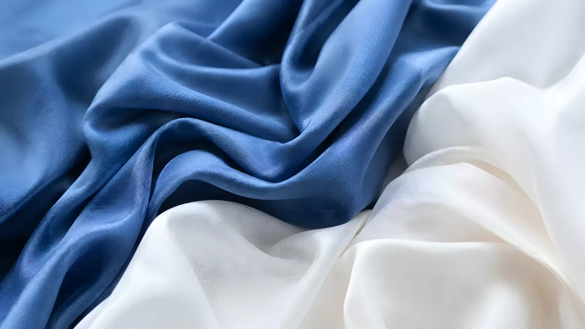 Blaues und weißes Seidenstoff in eleganten Falten
