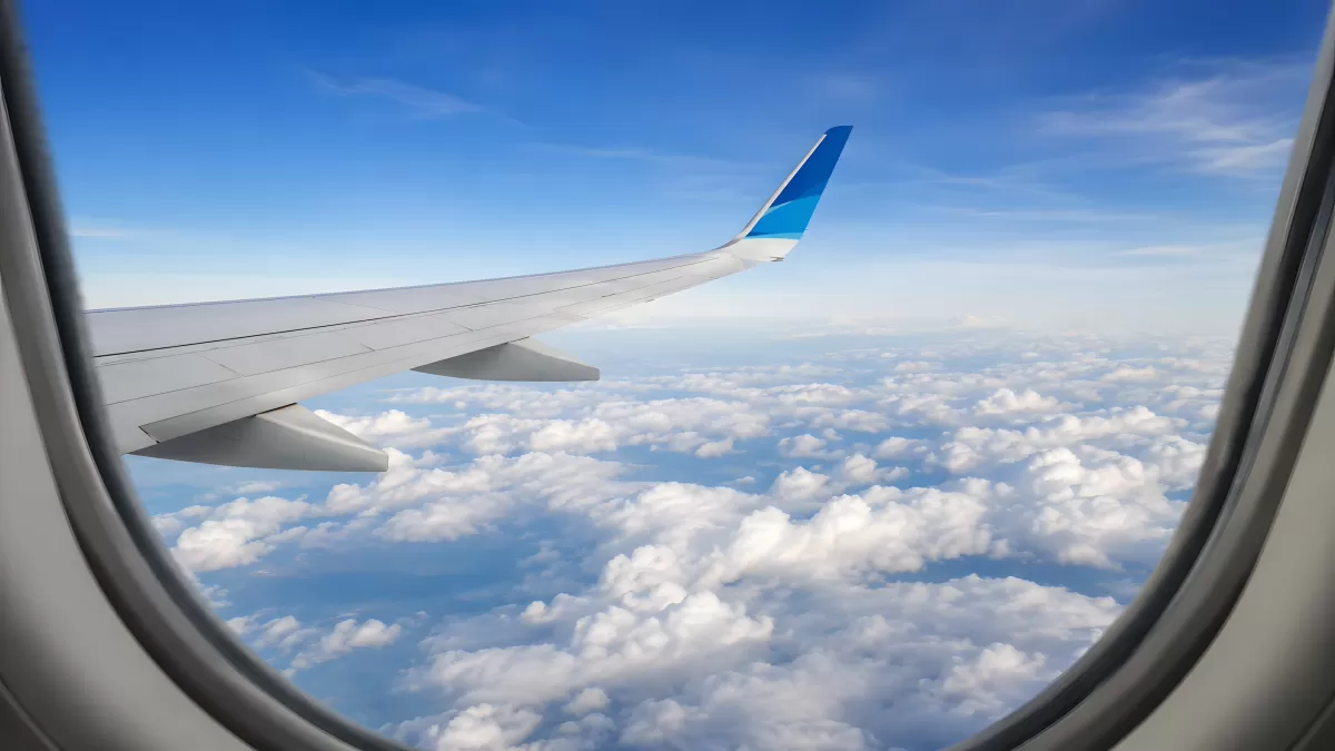 Blick aus dem Flugzeugfenster auf Wolken und Tragfläche