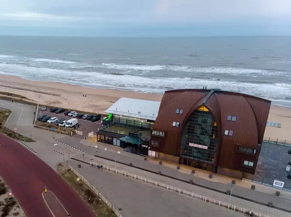 Blick aus der Luft über Strand von Bloemendaal aan Zee mit Strandhotel Proeflokaal Bregje und Parkplätzen