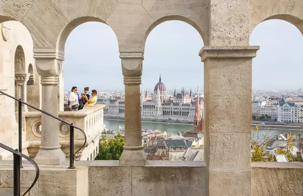 Blick durch die Säulen der Fischerbastei auf das Parlamentsgebäude und die Donau in Budapest