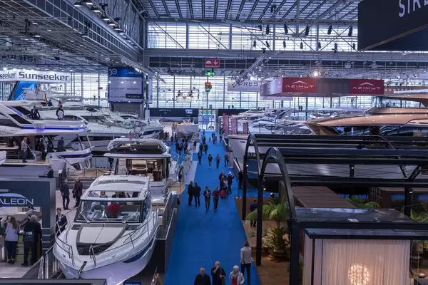 Blick über Ausstellungshalle mit Luxusjachten und Motorbooten mit interessierten Besuchern