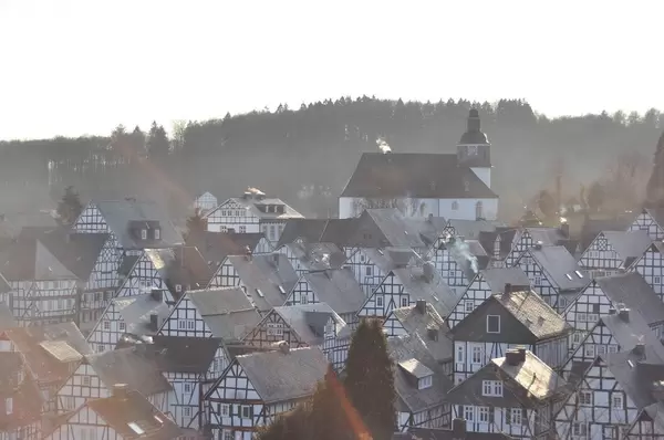 Blick über die Dächer von weißen Fachwerkhäusern auf Kirche des Dorfs Freudenberg
