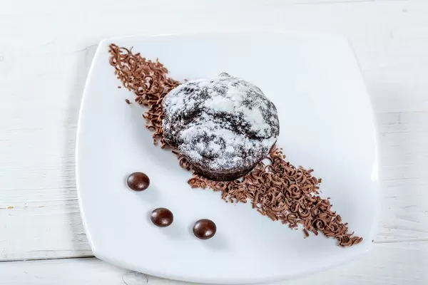 Blick von oben auf appetitlich angerichteten Nachtisch mit Schokolade und Puderzucker