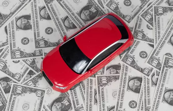 Blick von oben auf rotes Auto auf Hintergrund aus Banknoten