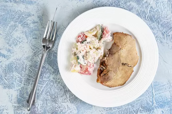Blick von oben auf Schweinefleisch und Schopska-Salat mit Salzlakenkäse aus Serbien