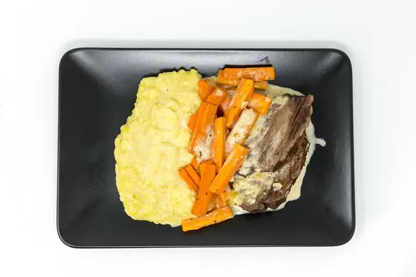 Blick von oben auf Teller mit Tafelspitz, Karotten und Kartoffelpüree von Lieferdienst