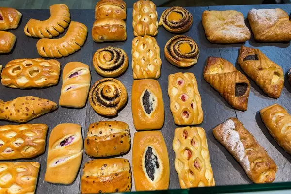 Blick von oben auf verschiedene Backwaren mit Mohn, Pudding, Rosinen und Puderzucker