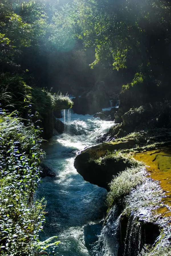 Blick von oben auf zwischen Felsen liegenden Cahabon River mit Lichteinfall