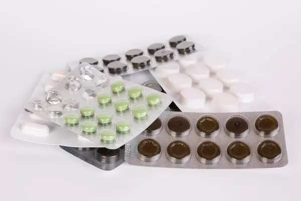 Blisters of pills on white table