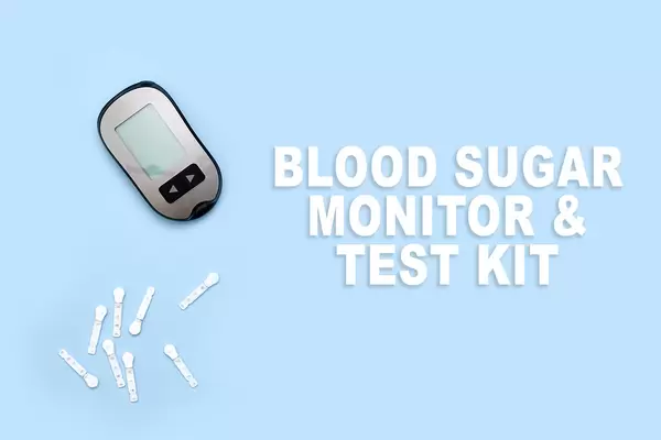Blood sugar monitor and test kit on blue background