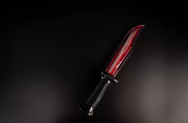 Bloody knife lies on a black background