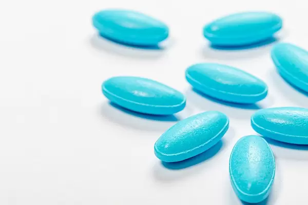 Blue antibiotic pills on white background (Flip 2019)