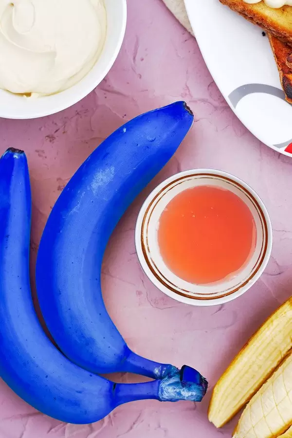 Blue bananas with a cup of tea. Symbol of poisonous food, pop art, difference