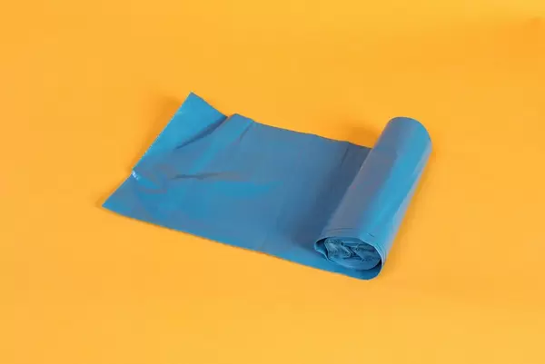 Blue bin bag roll on orange background