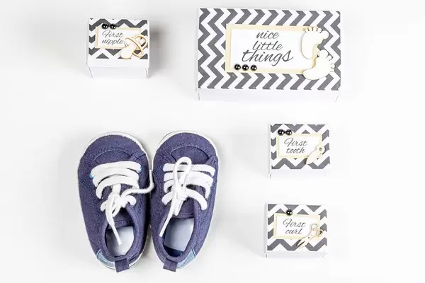 Blue boxes and little sneakers. Boy baby expectation concept, top view
