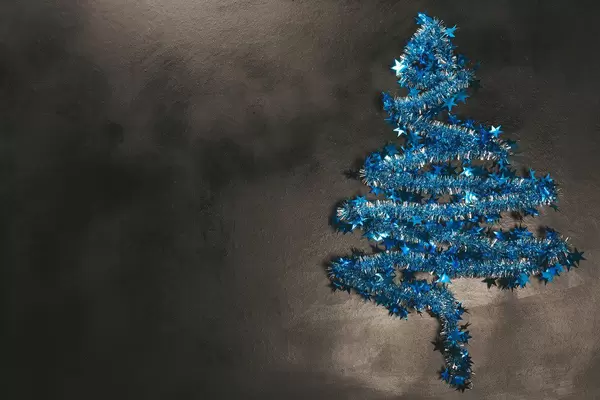 Blue Christmas tree on a dark background with free space