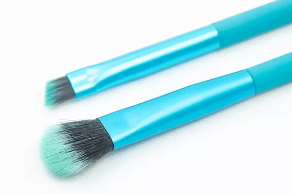 Blue Cosmetic Brushes above white background