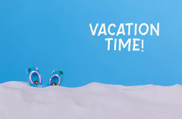 Blue flip flops on the beach with Vacation time text