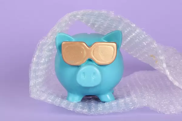 Blue piggy bank packed in bubble wrap