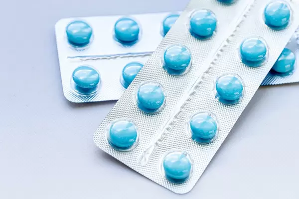 Blue pills in packs on white background (Flip 2019) (Flip 2019)
