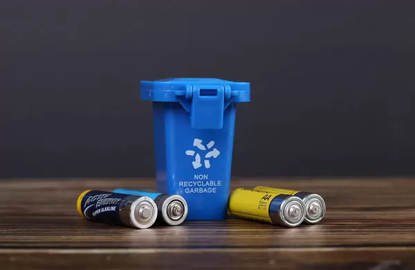 Blue recycle bin with batteries