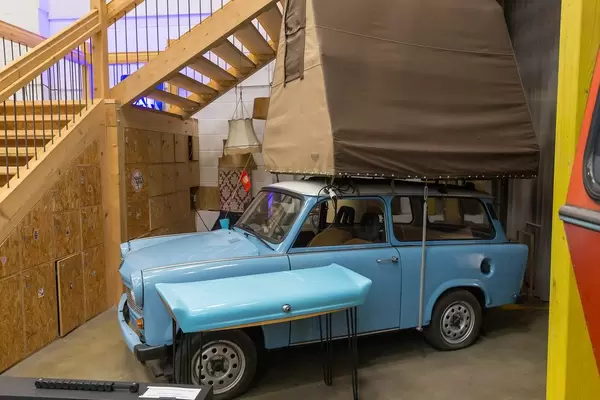 Blue retro car with white roof and brown tent construction on top of the roof