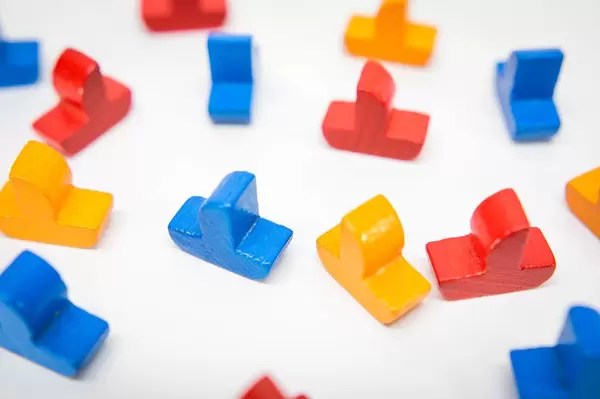 Blue, yellow, and red wooden boats on a white surface