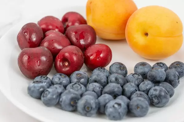 Blueberries Apricots and Cherries arranged on the plate