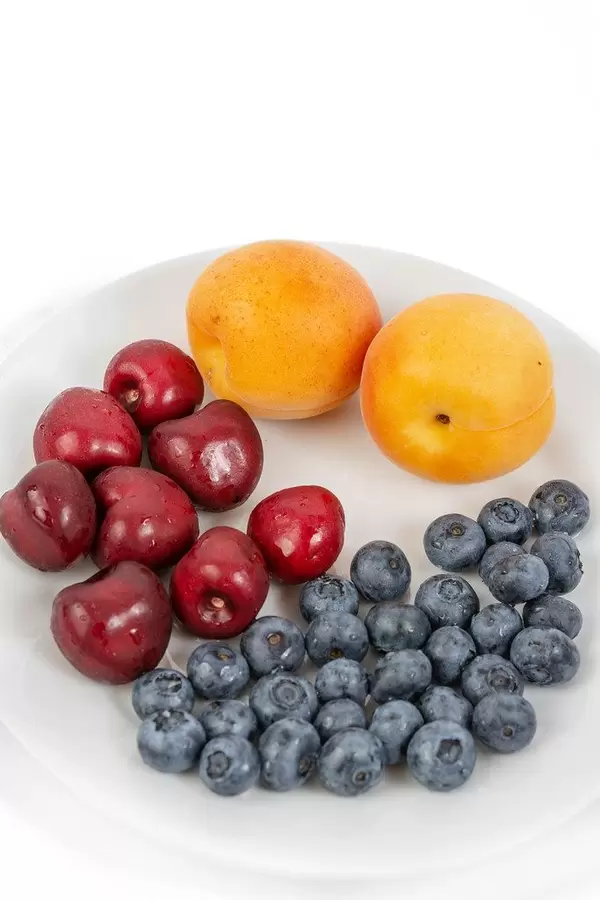 Blueberries Apricots and Cherries on the plate