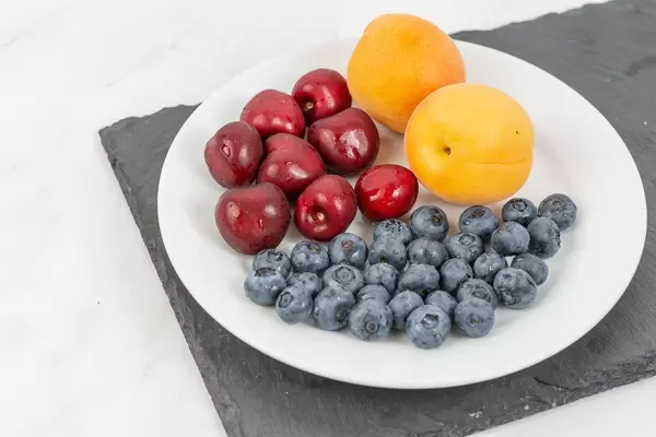 Blueberries Apricots and Cherries served on the plate