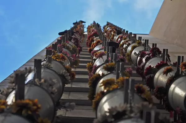 Blumen in Blecheimern an der Hausfassade